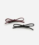 Set de dos pinzas para el pelo con forma de lazo, una color bordó y otra color negro.