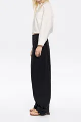 Pantalón negro de tejido técnico con corte barrel, cierre de corchete oculto y cremallera, trabillas ajustables en cintura y bajo, bolsillos delanteros en costuras y bolsillos con vivo en la parte posterior.