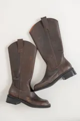 Bota de cuero color gris gastado, de caña alta y punta cuadrada.
