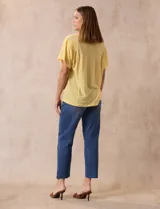 Remera amarilla de lino y poliéster, manga corta con fruncido en los hombros y escote redondo.