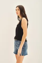 Top sin mangas color negro con escote en U pronunciado, tejido en punto compacto de textura sedosa y brillante.