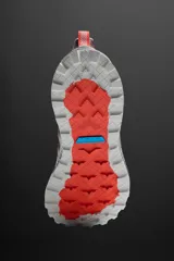 Zapatilla deportiva para carreras de montaña color borgoña con detalles en naranja y verde. Parte superior fabricada en tejido de punto transpirable con puntera y talón recubiertos de material Shield Protect Max. Ajuste de cordones mediante pieza técnica y suela con tecnología Spume Foam.
