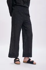 Pantalón negro con bordado calado, de corte palazzo y tiro alto.