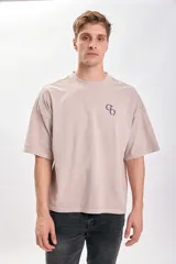 Camiseta manga corta color beige con estampa GO en el frente. Corte holgado y cuello redondo.