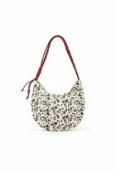 Cartera tipo media luna con estampado animal print en tonos blanco y negro, y asa de hombro trenzada en color bordó.