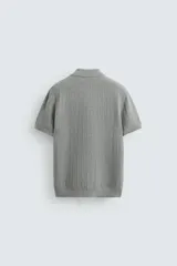 Polo gris de punto con textura, corte regular fit, cuello solapa y cierre frontal con botones.