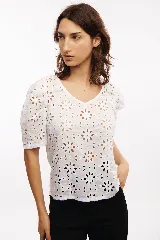 Blusa blanca con mangas cortas abullonadas y bordado calado con motivos florales. Incluye musculosa blanca para usar debajo.