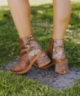 Bota corta de cuero marrón con detalle de cuero con textura de cocodrilo en el lateral y en el taco. Tiene cierre del lado interno y taco de madera forrada en cuero de 7cm.