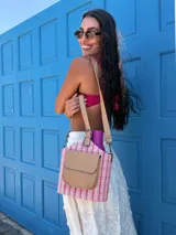 Matero tipo balde con cuerpo de tela a rayas verticales blancas y celestes pálidas. Posee un bolsillo frontal de símil cuero color camel con solapa y logo grabado. Incluye asa de mano y correa larga desmontable.