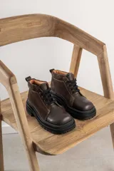 Borcegos negros de cuero charol, con punta cuadrada, cordones y suela track.