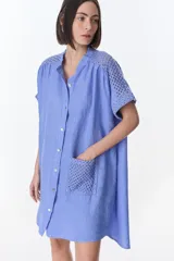 Vestido camisero celeste de lino con cuello mao, manga corta con detalle de crochet en los hombros y bolsillo de crochet en el frente.