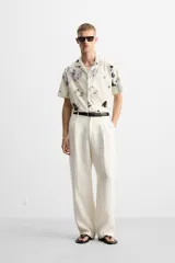 Camisa de manga corta con cuello bowling y estampado floral en tonos blanco y negro.