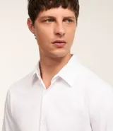 Camisa de hombre, corte slim, color blanco, confeccionada en algodón y poliéster con tecnología Easy Care que ofrece elasticidad y secado rápido. Presenta cuello inglés y manga larga con puño abotonado.