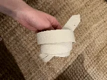 Cinturón de cuero negro, delgado y liso, con terminación en lazo.