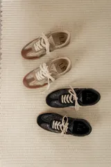 Championes acordonados color beige y dorado con suela marrón.