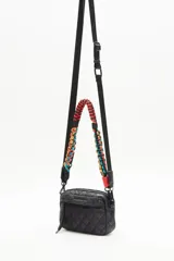 Bandolera negra de nylon matelassé con correa larga regulable y correa corta desmontable de cordones trenzados multicolores. Tiene cierre superior, bolsillo frontal con cierre, bolsillo trasero y dos bolsillos internos.