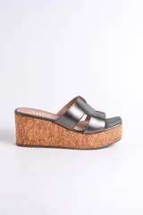 Sandalia dorada con plataforma de corcho y tiras cruzadas.