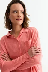 Cardigan negro de manga larga, con cuello camisero, botones frontales y un bolsillo en el pecho.