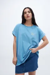Musculosa celeste con estampado pequeño en el pecho, corte oversize y mangas con dobladillo.