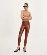 Pantalón skinny de sarga color marrón con textura resinada, cintura alta, trabillas para cinturón y bolsillos.