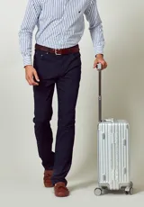 Pantalón de vestir azul marino, de corte recto, con bolsillos laterales y traseros. Se ajusta a la cintura con cinturón de cuero marrón.