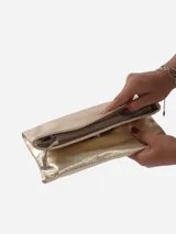 Sobre de fiesta negro charolado con cierre de solapa imantada y tira de cuero para sujetar a la muñeca.