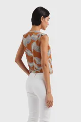Chaleco marrón con estampado de hojas en tonos celeste y blanco, escote en V y cierre frontal con botones.