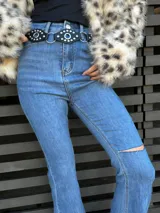 Pantalón de jean azul de tiro alto, corte semioxford y detalle de rotura en la rodilla.