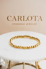Pulsera elastizada de cuentas de acero quirúrgico con baño de oro 18k.