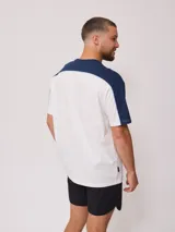 Remera de hombre azul marino con mangas y cuello amarillo, y logo de la marca Rusty estampado en el pecho.