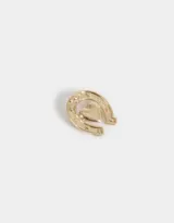 Pin dorado con forma de herradura y corazón.
