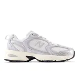 Championes New Balance 530 color plateado y blanco, con capellada de malla y superposiciones de cuero sintético. Entresuela ABZORB para mayor amortiguación.