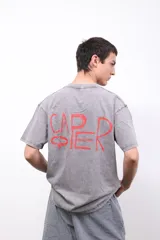 Remera de algodón gris con efecto gastado (acid wash) y estampa en la espalda con la palabra "CAPER" en letras rojas escritas a mano.