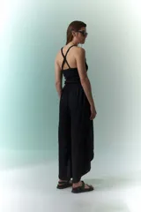 Pantalón negro de lino con tajos laterales amplios.