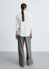 Camisa blanca de popelina de algodón y lyocell, corte recto, manga larga con puños abotonados y cuello camisero.