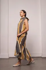 Vestido largo y amplio con cuello alto y mangas cortas abullonadas. Diseño a rayas verticales en tonos dorado y gris. Incluye viso liso al tono.