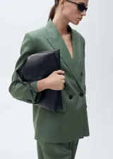 Blazer verde musgo de lino, con solapas de muesca, cierre cruzado con doble botonadura, mangas largas con puños abotonados, diseño recto, forro interior y dos bolsillos de solapa frontales.