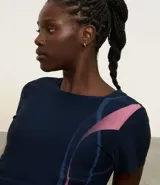 Remera deportiva de microfibra color azul marino con mangas cortas y estampado de ondas en rosa y azul.