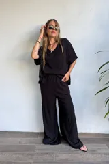 Remerón negro de lino, con escote en V y mangas murciélago amplias.