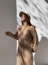 Conjunto deportivo color beige de tela waffle, compuesto por un buzo de corte cropped y un pantalón con cordón ajustable.