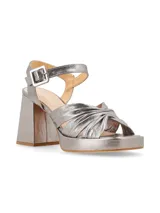 Sandalias plateadas con plataforma y tacón cuadrado, tiras cruzadas en el empeine y pulsera con hebilla al tobillo.