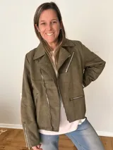 Campera biker verde oliva de gamuza sintética suave, con cierre asimétrico metálico, bolsillos y mangas con cremalleras.