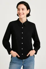Camisa negra de manga larga con cuello clásico y cierre frontal con botones.