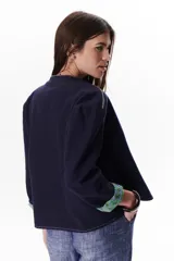 Chaqueta color crudo de lino con corte con vivos a contratono y forros estampados.