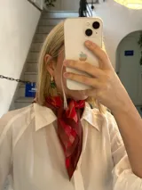 Pañuelo cuadrado de seda color rojo con estampado geométrico en tonos de rojo y marrón.