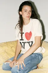 Remera color crudo de corte holgado con mangas cortas y cuello redondo. Estampado frontal con el texto "I ❤️ NY" en color negro y rojo.