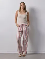 Pantalón de lino a rayas verticales color beige, azul y naranja, con pretina elastizada, lazo de ajuste y bolsillos inclinados.