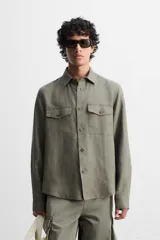 Sobrecamisa verde militar de lino, corte relaxed fit, con cuello solapa, manga larga con puños abotonados, bolsillos de parche con solapa en el pecho, aberturas laterales en el bajo y cierre frontal abotonado.