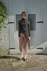 Polera negra de microtul y lycra compression, con cuello alto, mangas largas y puños de lycra. Presenta una abertura sutil en los puños.
