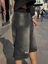 Short de jean negro con efecto lavado, corte a la rodilla y estampado con el logo de la marca en blanco en la pierna izquierda.